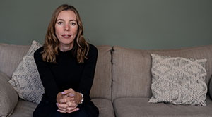 Vicki Macdonald sits on a sofa with her hands clasped together on her knees