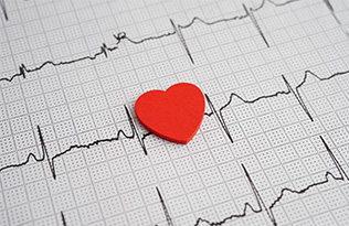 A cut out shape of a heart on top of an ECG reading.