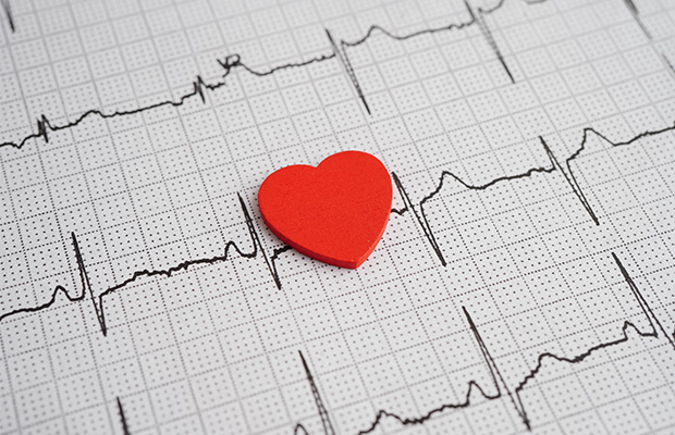 A cut out shape of a heart on top of an ECG reading.