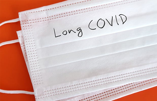 A disposable face mask with "Long Covid" written on it.