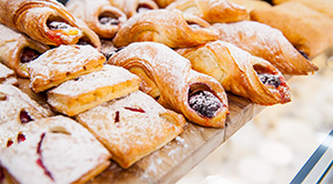 Pastries covered in sugar on a counter in a bakery.