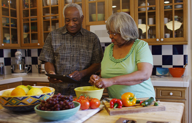 A couple cooking a healthy meal together in a kitchen.