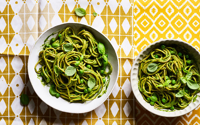 Two bowls of green pesto pasta
