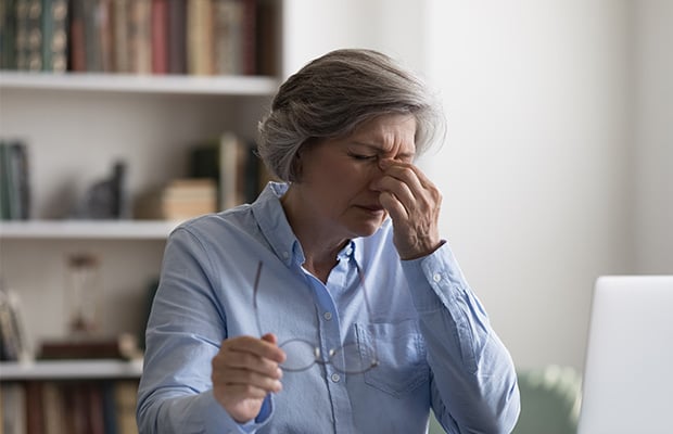 A tired woman sitting at a desk.