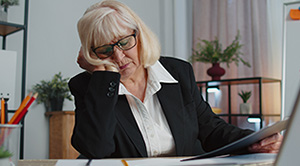 A person in business clothing dozing at her desk due to fatigue.