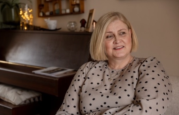 Gini Dellow sits near a piano in her home in Northamptonshire.