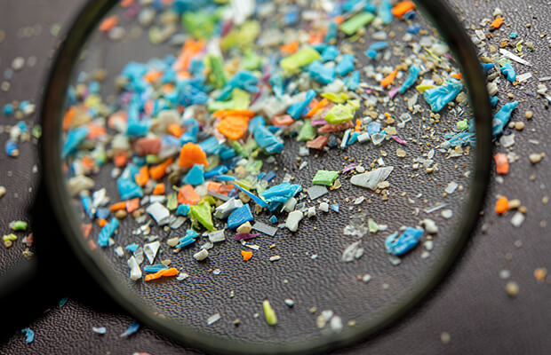 Multicoloured microplastics under a magnifying glass 