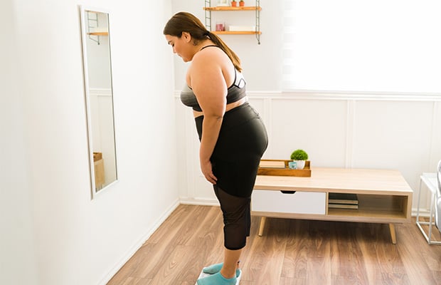 A woman standing on weighing scales at home