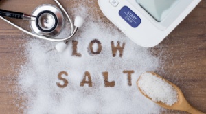The words low salt written in a spread of white salt on a wooden table