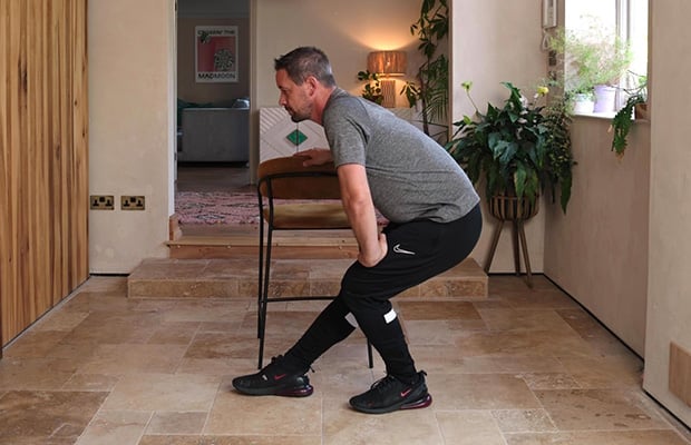 Andrew Scard demonstrates a hamstring stretch.