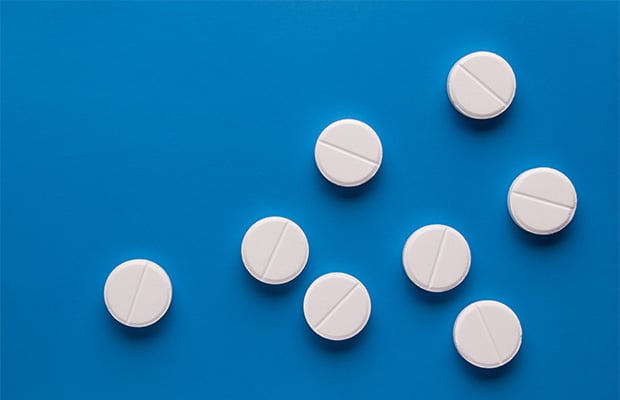 Round white pills on a blue background.