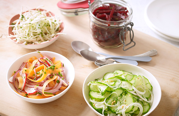 3 bowls and 1 jar of different types of pickles.