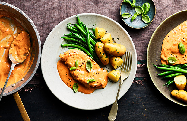A plate of chicken, potatoes and green beans on a table.