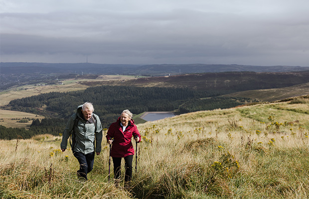 Helen standing with her husband on a hill.