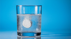 A tablet dissolving in a glass of water.