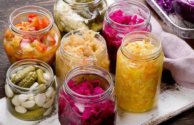 Collection of jars with colourful fermented foods inside,
