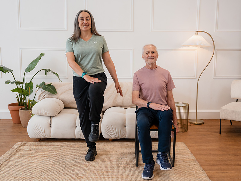 Hara Markos and Peter McCudden performing a knee raise with a hand tap.