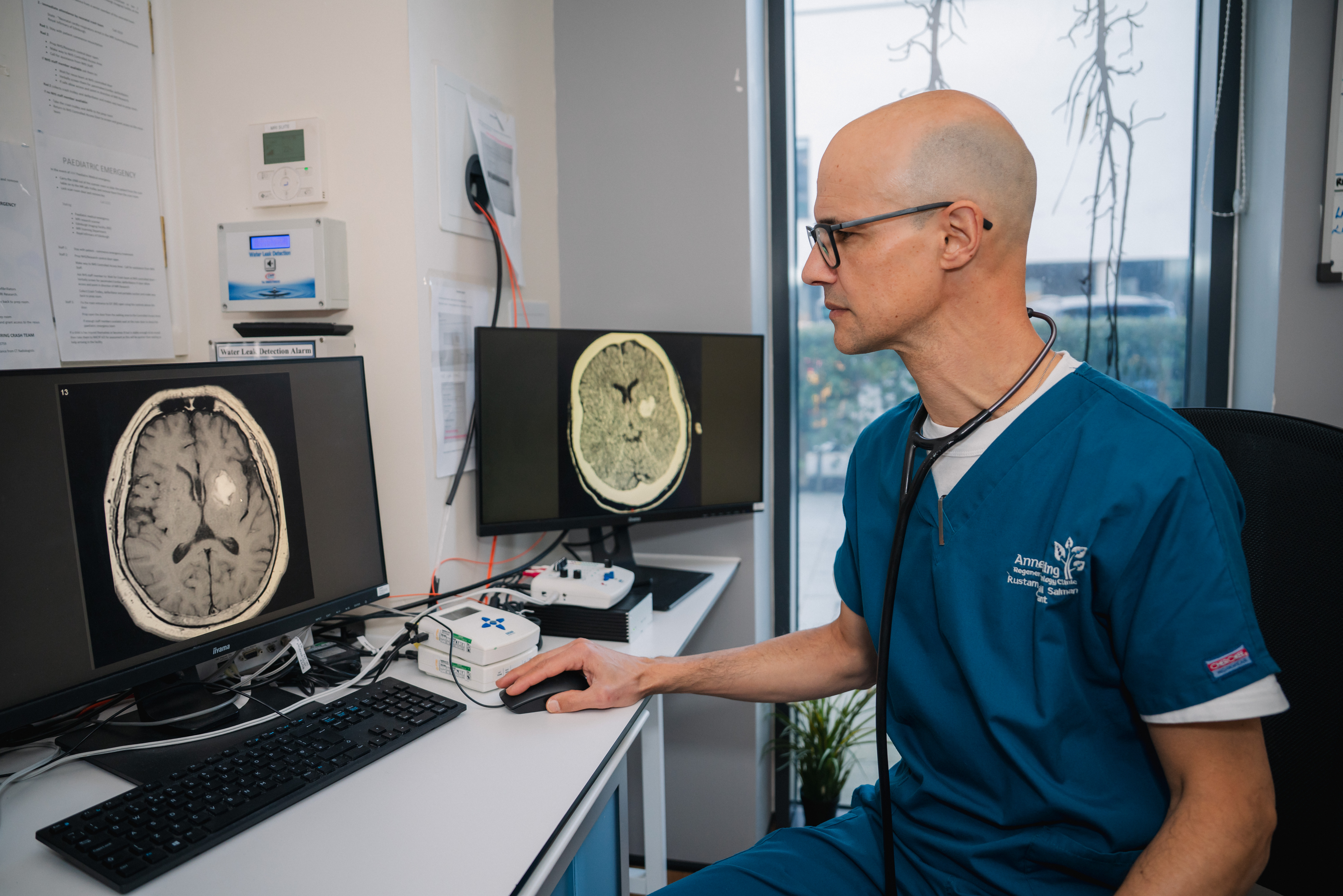Professor Rustam Al-Shahi Salman examines a scan image on a computer showing a haemorrhagic stroke.