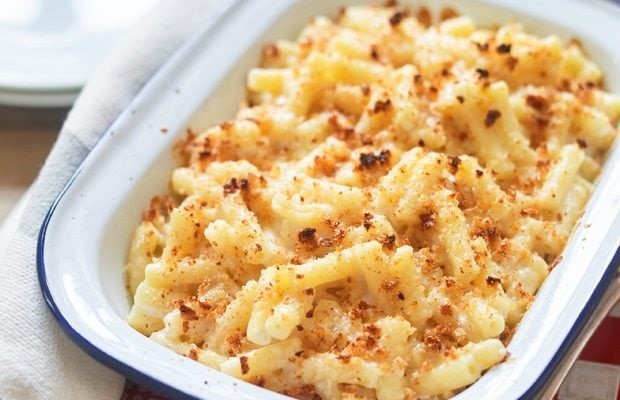 Close up of a white enamel dish with oven-baked macaroni cheese in.