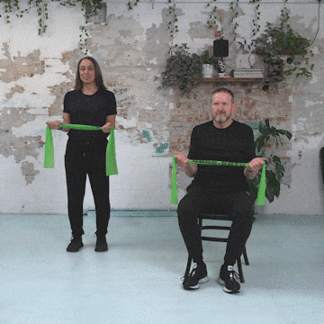 Hara and Peter performing a standing and seated dumb waiter exercise.