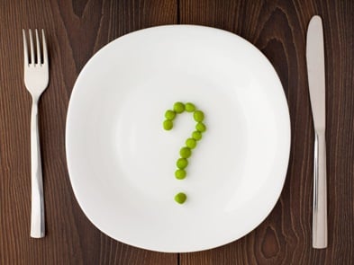 Peas arranged in the shape of a question mark on a plate.