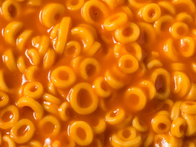A close-up of spaghetti hoops pasta in tomato sauce.