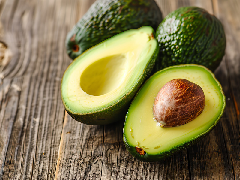 An avocado cut in half on a table.