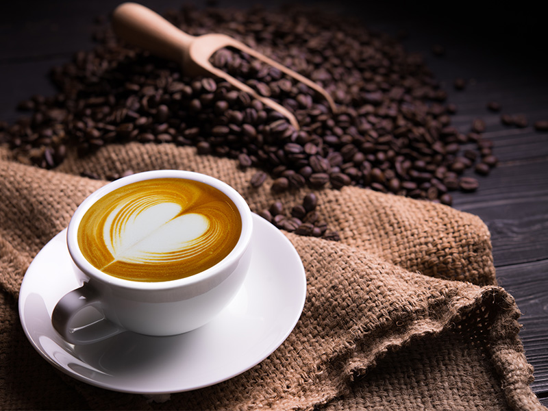 coffee cup with latte art and coffee beans