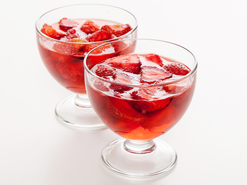 Two glass bowls containing strawberry jelly.