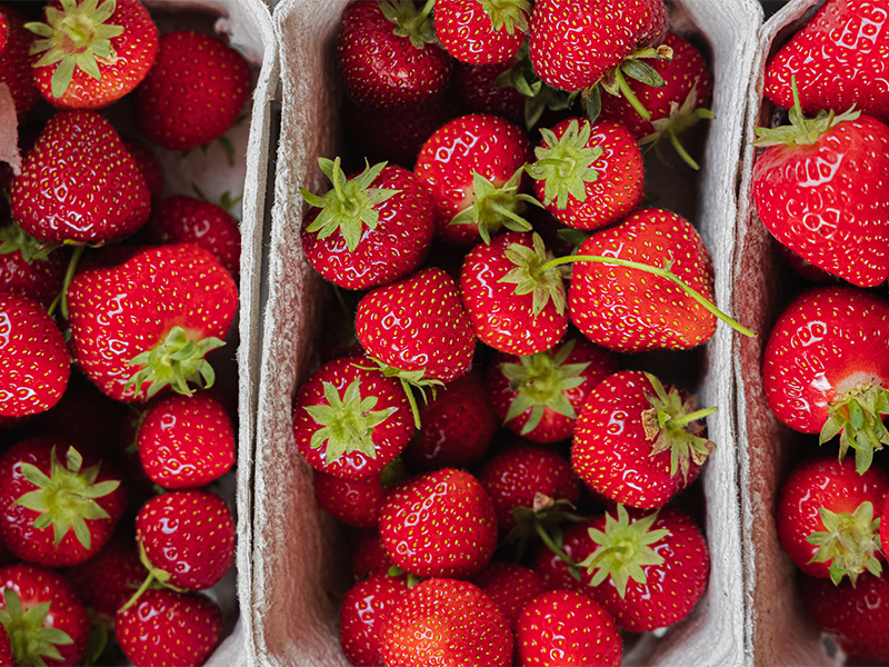 An aerial view of 3 punnets of strawberries.