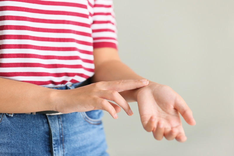 A person checks the radial pulse over their left wrist using their right hand