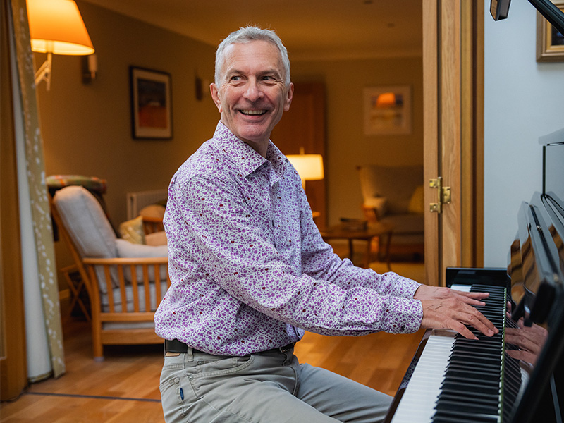Philip Hollows sat at the piano in his home.