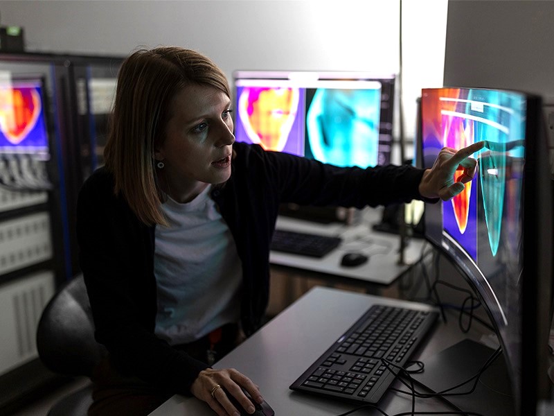 Dr Marie Holt looking at brain scans in a lab.