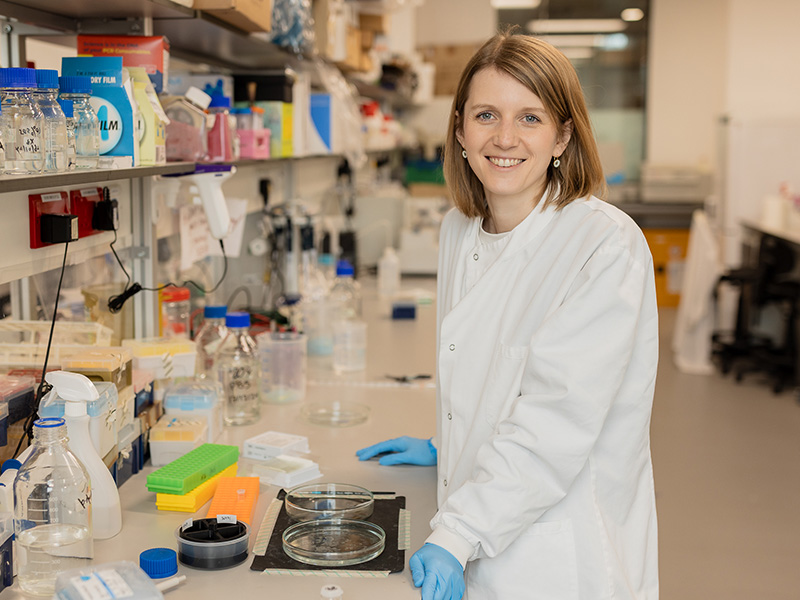 Dr Marie Holt standing in a lab.