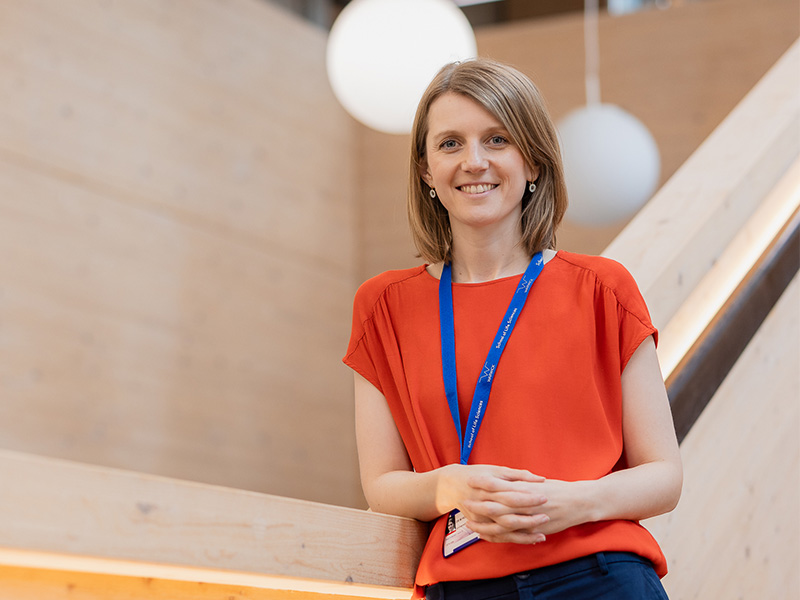 Dr Holt standing on stairs in a university building.