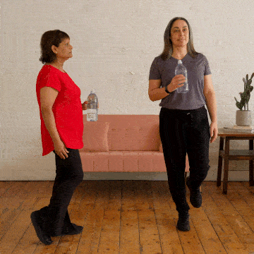 Corinne and Hara demonstrating a single leg balance with weight.