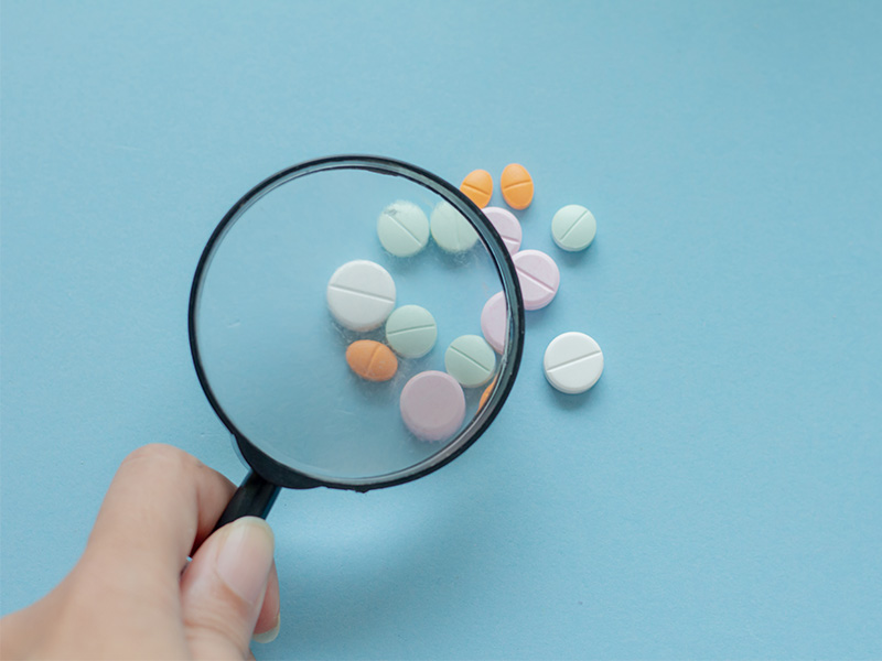 A magnifying glass held over some tablets.