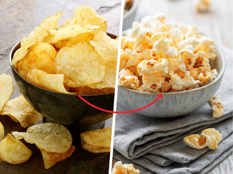 Half the image shows a bowl of crisps, the other half shows a bowl of plain popcorn. This is an example of healthy food swaps that help lower cholesterol.