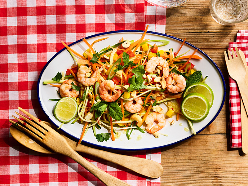 A plate of Thai prawn and mango salad on a table.