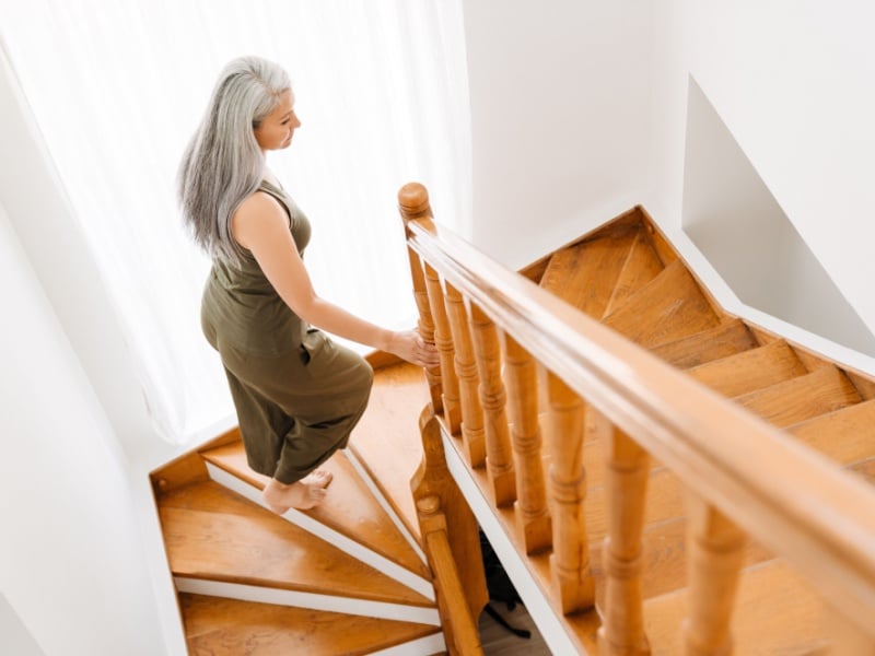 A woman climbing a flight of stairs at home.