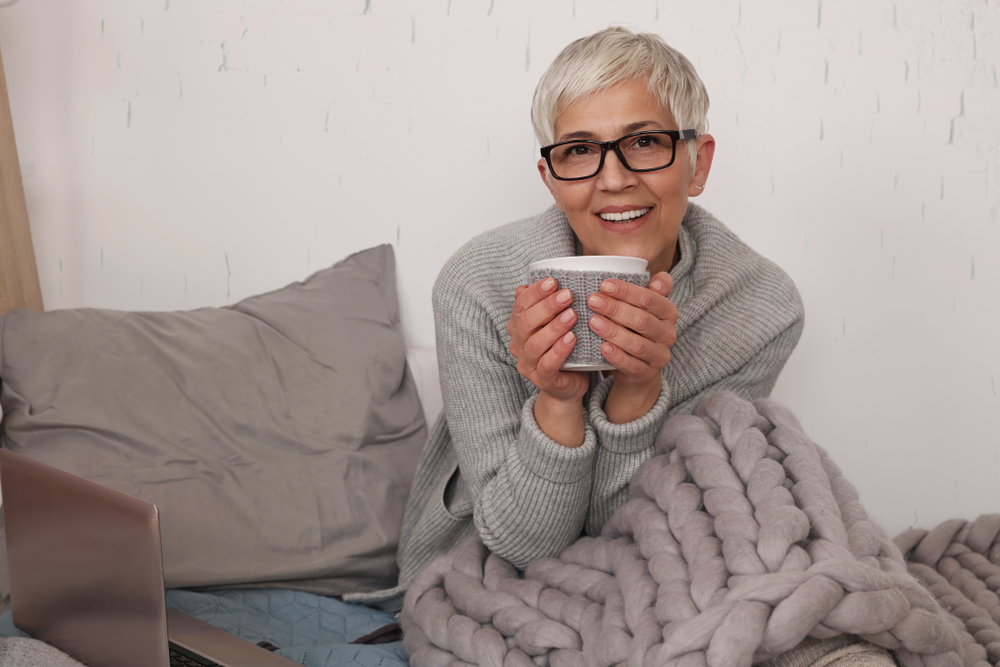 Older woman in bed drinking coffee