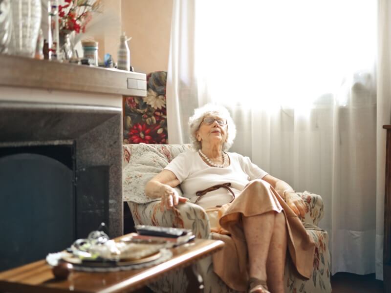 A woman sleeping upright in a chair at home.