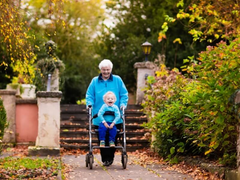 A woman walking using a walking aid with a young child.