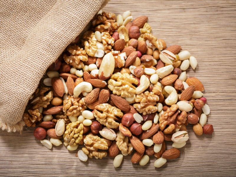 A bag of mixed nuts spilling out onto a table.