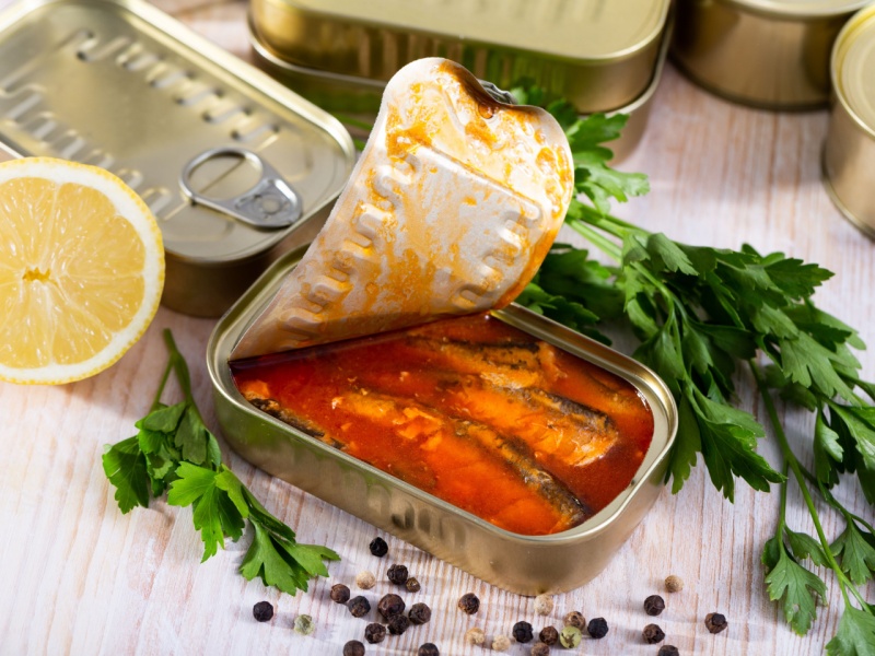 Sardines in tomato sauce in open tin can.