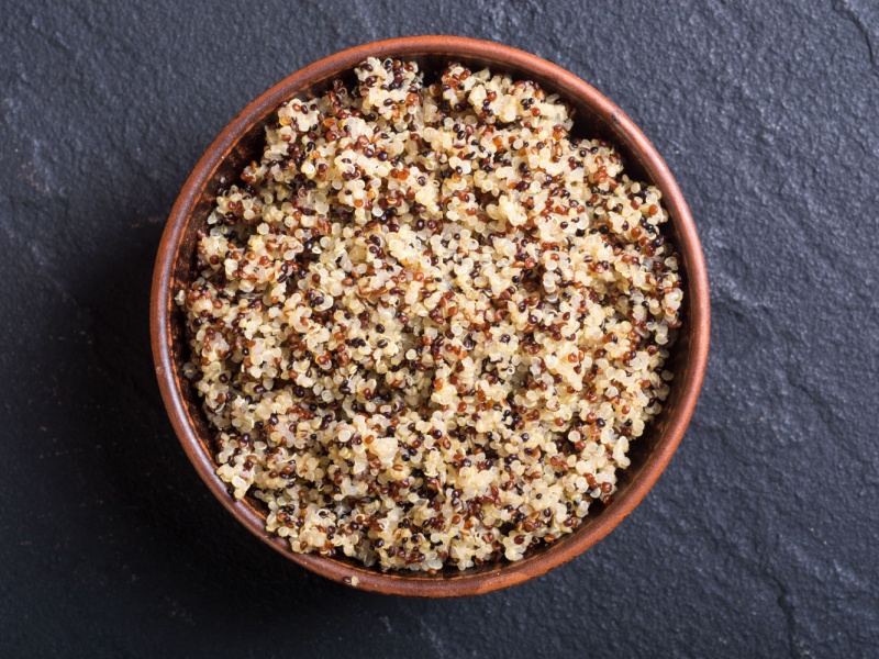 A bowl of cooked quinoa in a brown bowl