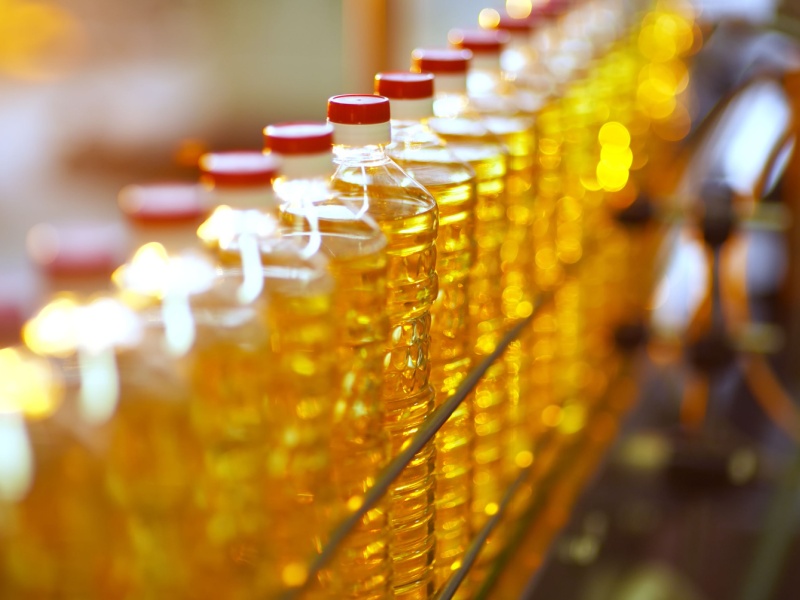 A row of seed oils in plastic bottles.