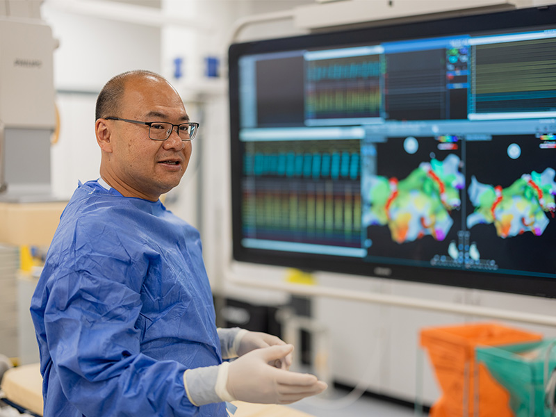 Professor Fu Siong Ng standing in front of a screen showing an ablation procedure.