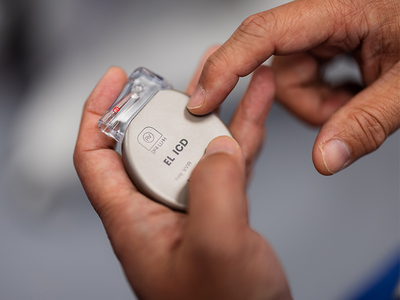 Professor Ng holding an ICD (implantable cardioverter defibrillator) device.