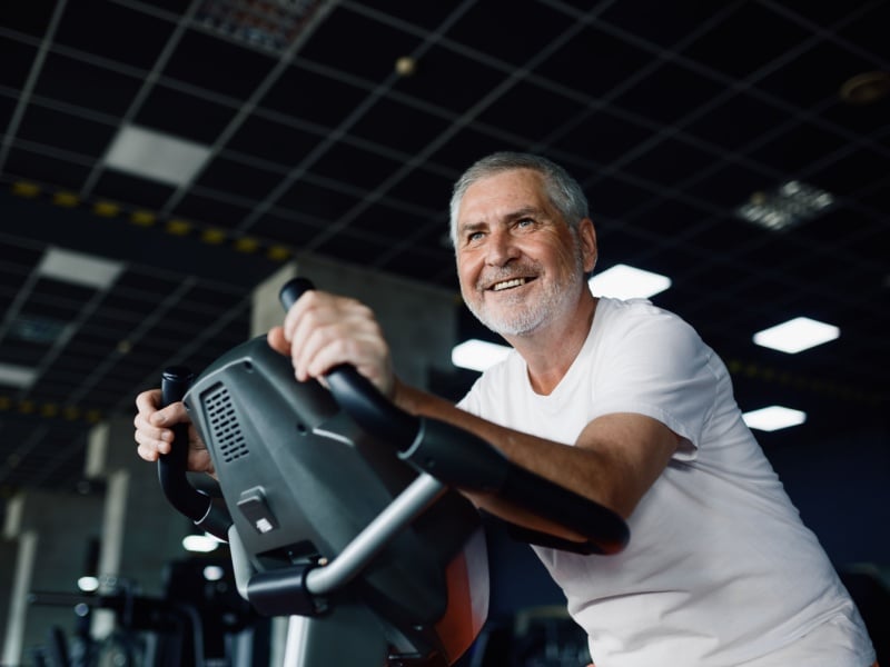 A man on an exercise bike in a gym.